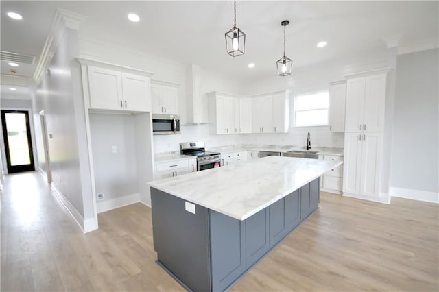134 Gourgues St, Hahnville, LA 70057 - kitchen with stainless steel appliances, a kitchen island, a sink, white cabinetry, and wall chimney exhaust hood