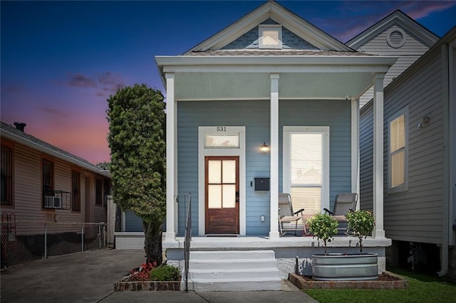 view of front of property with a detached garage and covered porch