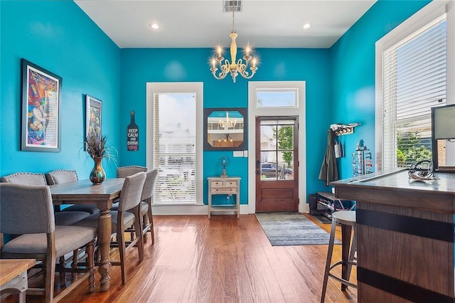 dining space with visible vents, baseboards, a chandelier, recessed lighting, and wood-type flooring