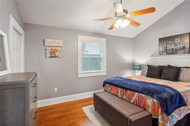 bedroom featuring baseboards, vaulted ceiling, a ceiling fan, and wood finished floors