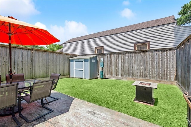 view of yard featuring an outbuilding, a fenced backyard, a patio area, and a storage unit