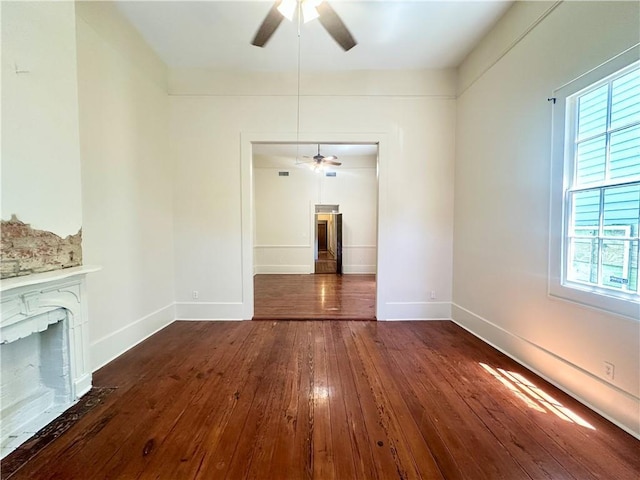 723 Port St, New Orleans, LA 70117 - unfurnished living room featuring a ceiling fan, dark wood-style floors, baseboards, and a fireplace