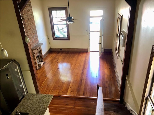 723 Port St, New Orleans, LA 70117 - unfurnished living room with wood-type flooring, baseboards, and a ceiling fan