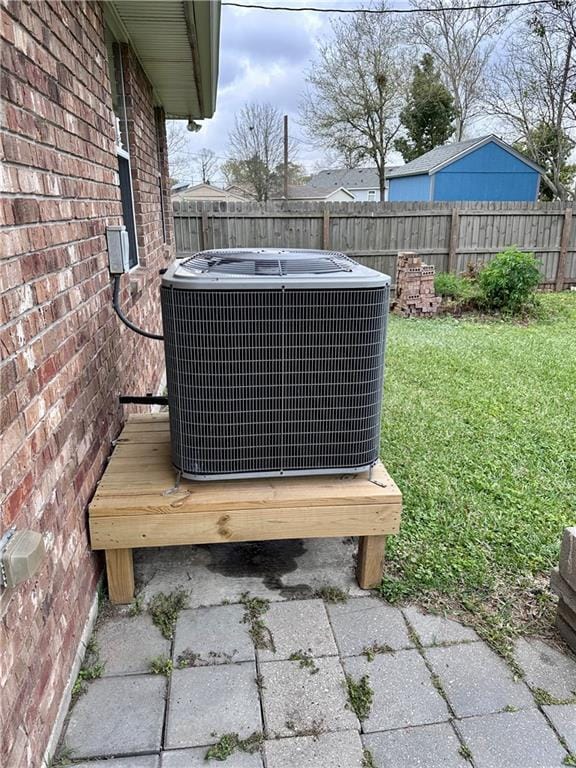 exterior details featuring brick siding, central AC, and a fenced backyard