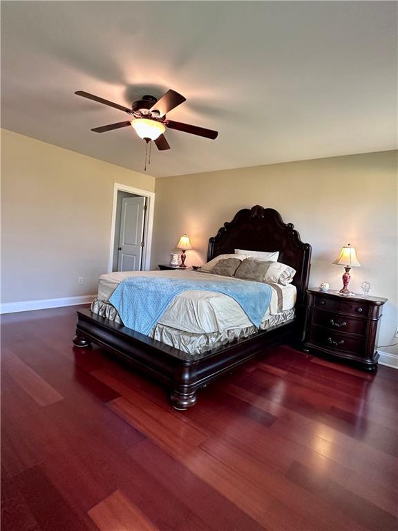 bedroom with a ceiling fan, baseboards, and wood finished floors