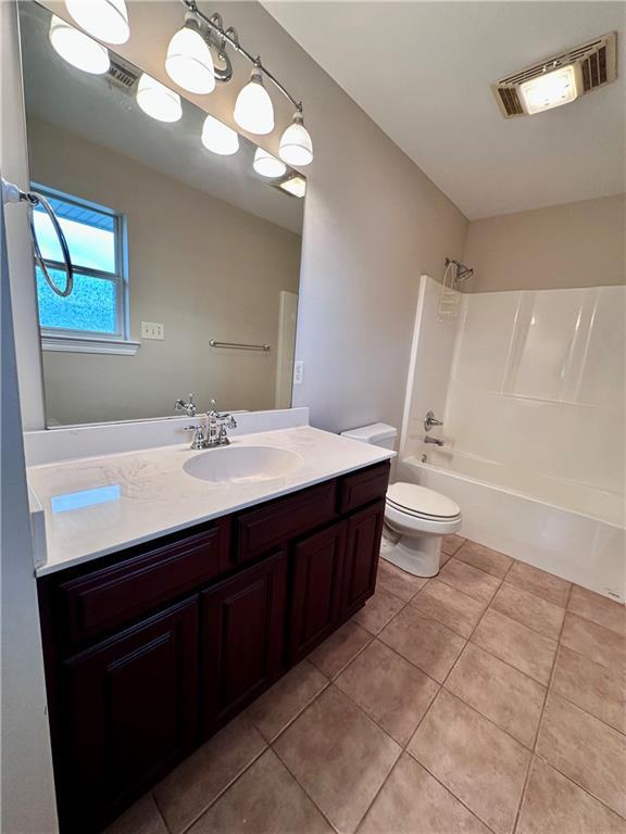 bathroom with vanity, toilet, bathtub / shower combination, and visible vents
