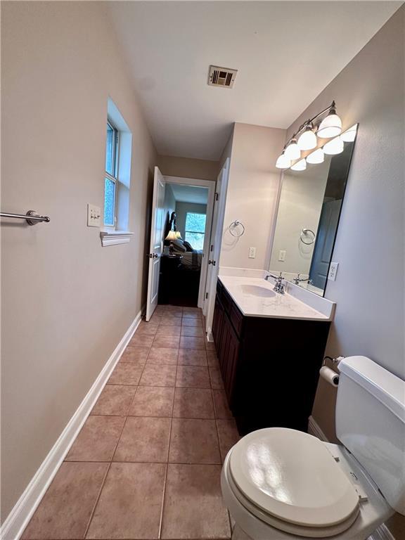 bathroom with visible vents, toilet, tile patterned flooring, baseboards, and vanity