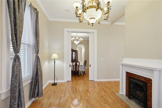 unfurnished living room featuring a chandelier, a wealth of natural light, crown molding, and a brick fireplace