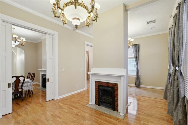 living room with visible vents, a notable chandelier, arched walkways, and a brick fireplace
