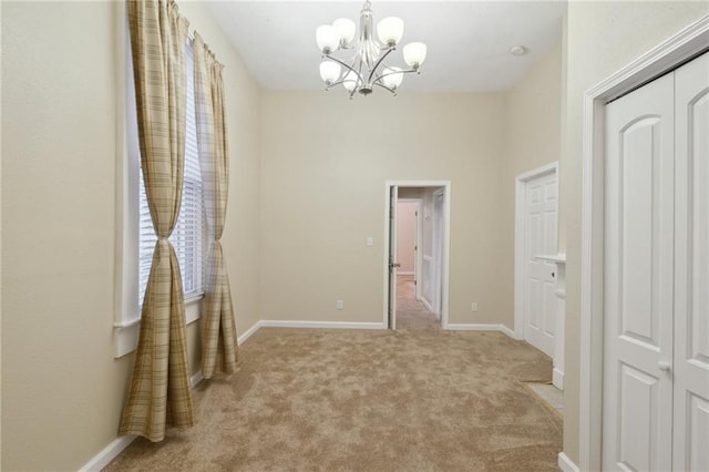unfurnished bedroom featuring baseboards, a notable chandelier, and carpet