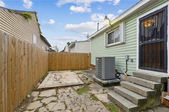 view of property exterior with a patio, a fenced backyard, cooling unit, a chimney, and entry steps