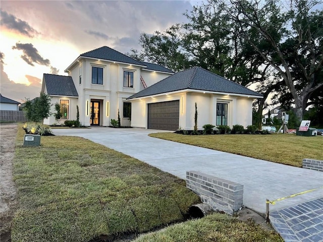 138 Wood Duck Dr, Belle Chasse, LA 70037 - modern inspired farmhouse with stucco siding, a front yard, driveway, an attached garage, and a shingled roof