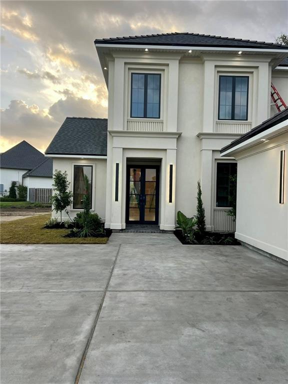 138 Wood Duck Dr, Belle Chasse, LA 70037 - view of front facade with french doors and stucco siding