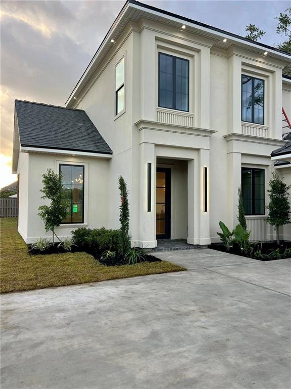 138 Wood Duck Dr, Belle Chasse, LA 70037 - view of front of house with stucco siding and a shingled roof