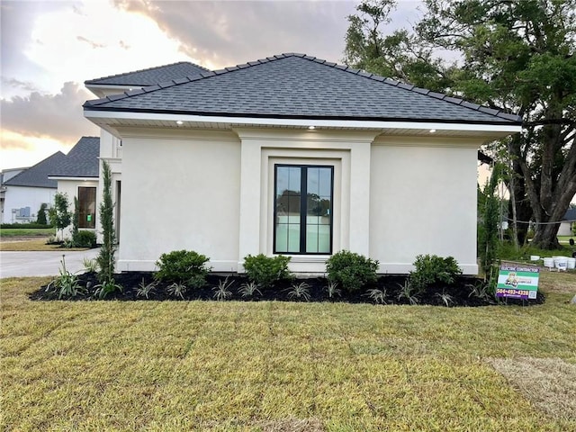 138 Wood Duck Dr, Belle Chasse, LA 70037 - view of side of property with roof with shingles, a yard, and stucco siding