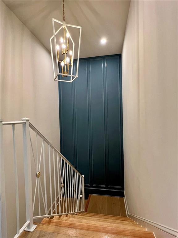 138 Wood Duck Dr, Belle Chasse, LA 70037 - staircase featuring a chandelier, wood finished floors, and a decorative wall
