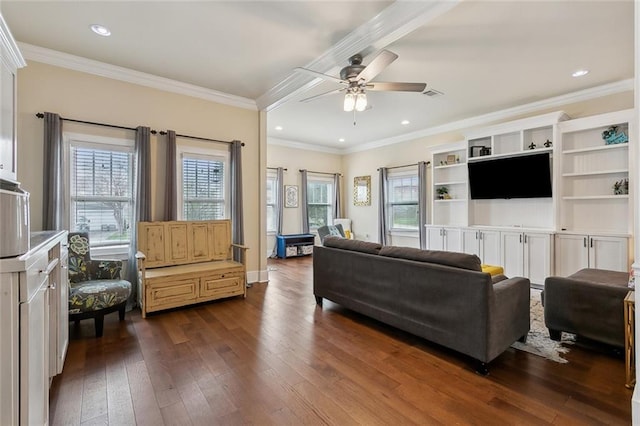 living room with dark wood-type flooring, a ceiling fan, visible vents, and a healthy amount of sunlight