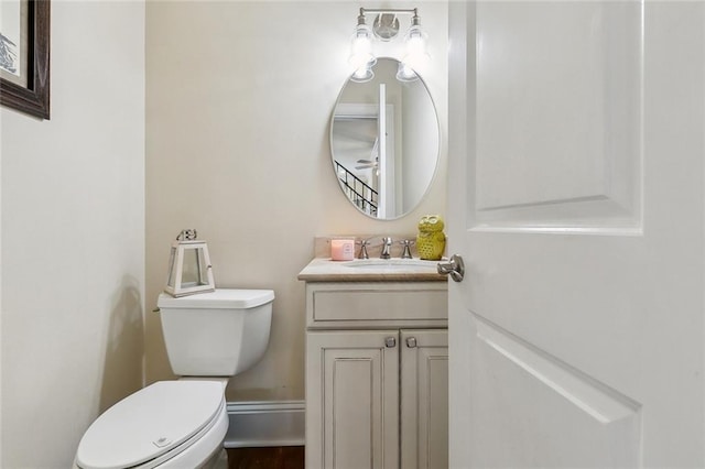 bathroom featuring baseboards, toilet, and vanity