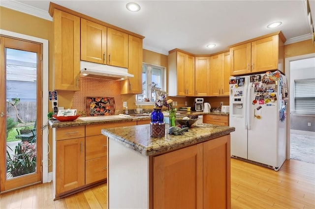 kitchen with white appliances, stone counters, light wood finished floors, ornamental molding, and under cabinet range hood