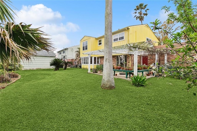 rear view of property with a patio, a yard, and a pergola