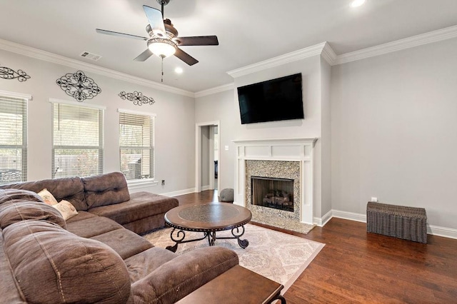 living area featuring crown molding, wood finished floors, baseboards, and ceiling fan