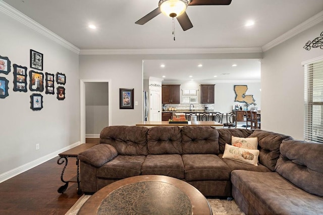 living room with baseboards, ceiling fan, ornamental molding, recessed lighting, and wood finished floors