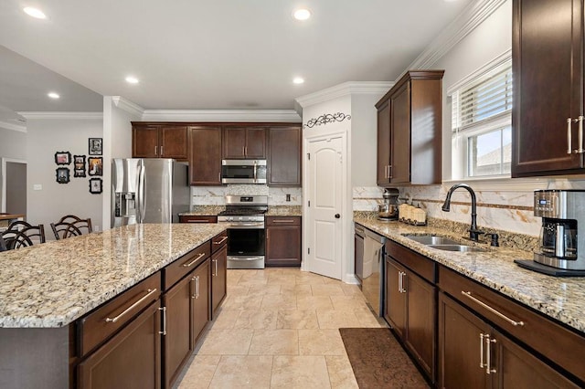 kitchen featuring light stone countertops, a kitchen island, a sink, stainless steel appliances, and dark brown cabinetry