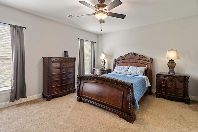 carpeted bedroom with multiple windows, baseboards, visible vents, and ceiling fan