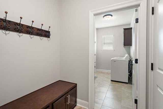 washroom with baseboards, washer / clothes dryer, cabinet space, and light tile patterned flooring