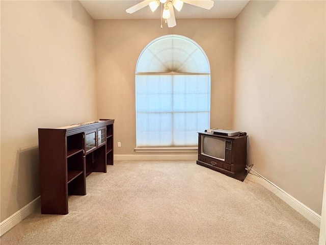 misc room with baseboards, carpet floors, and a ceiling fan