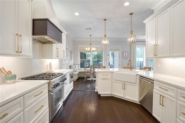 kitchen with premium range hood, appliances with stainless steel finishes, a peninsula, a notable chandelier, and a sink