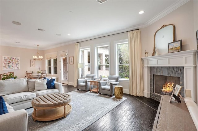 living room with visible vents, an inviting chandelier, a fireplace with flush hearth, dark wood-type flooring, and crown molding