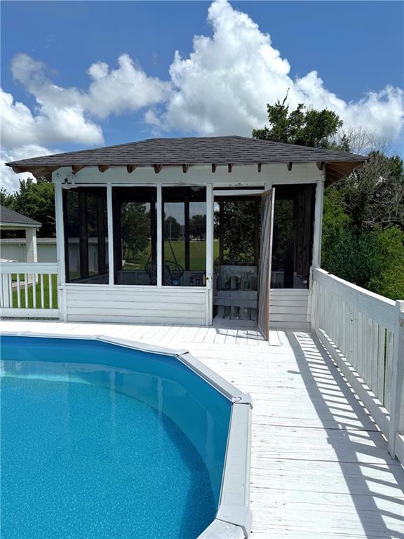 5227 Shady Park Dr, Marrero, LA 70072 - outdoor pool featuring a sunroom and a wooden deck