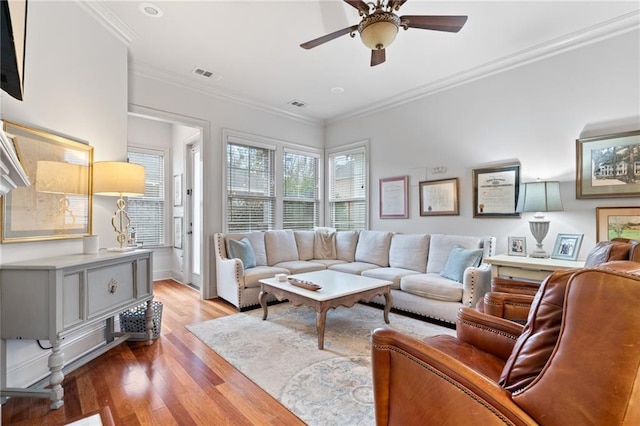 living room with visible vents, crown molding, ceiling fan, and wood finished floors