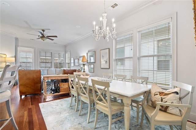 dining room with visible vents, wood finished floors, ornamental molding, and ceiling fan with notable chandelier