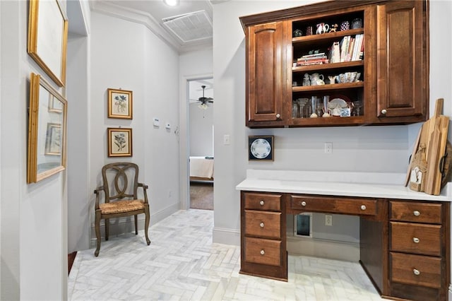 home office with baseboards, visible vents, built in study area, ceiling fan, and ornamental molding