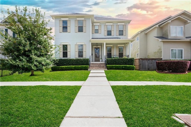 view of front of house featuring a front yard, a porch, and fence