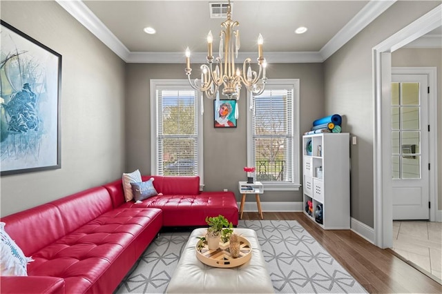 living area with a notable chandelier, visible vents, a wealth of natural light, and ornamental molding