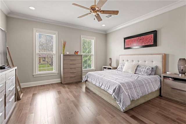 bedroom featuring crown molding, wood finished floors, and baseboards