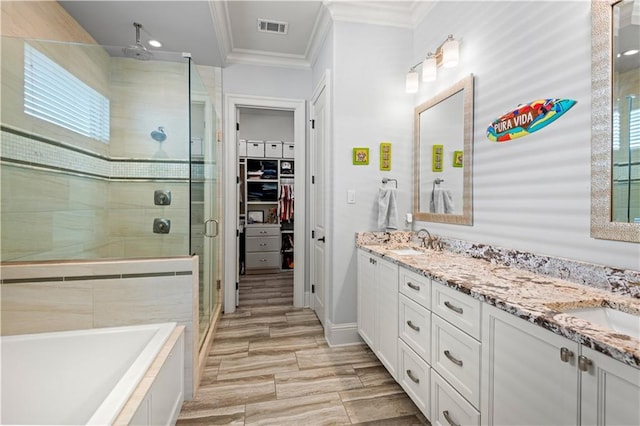 bathroom with visible vents, ornamental molding, a stall shower, and a sink