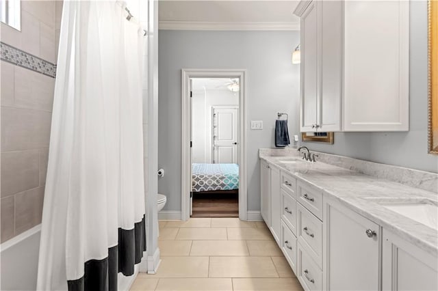 bathroom with crown molding, toilet, double vanity, tile patterned floors, and a sink