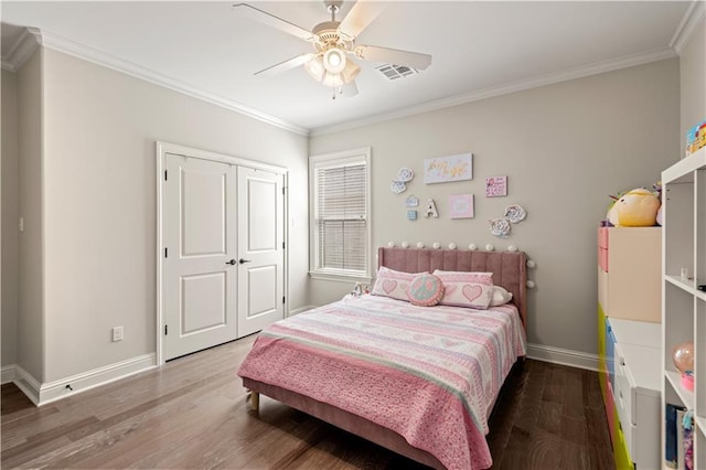 bedroom featuring baseboards, wood finished floors, visible vents, and ornamental molding