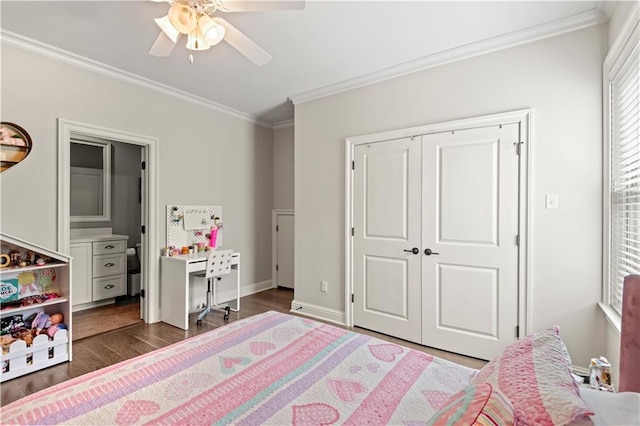 bedroom with crown molding, ceiling fan, baseboards, dark wood finished floors, and a closet