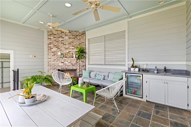 view of patio / terrace with exterior kitchen, a sink, ceiling fan, wine cooler, and outdoor lounge area