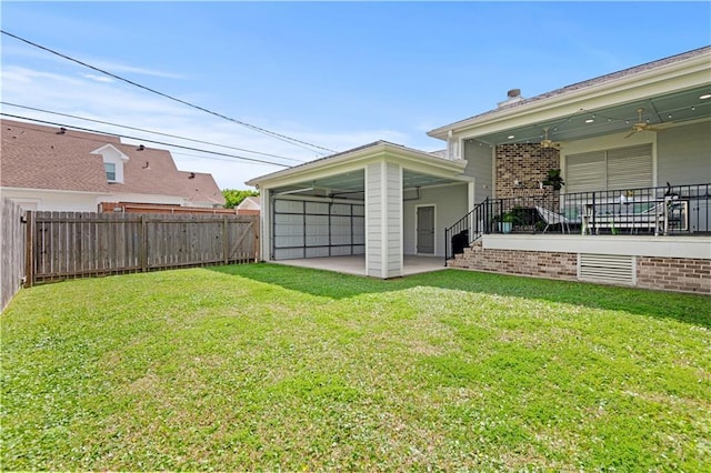 view of yard featuring a fenced backyard, ceiling fan, and a patio