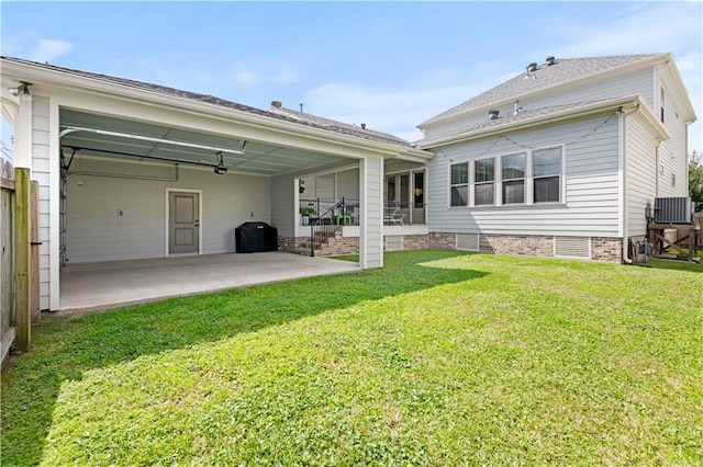 back of property with a yard, cooling unit, and a patio area