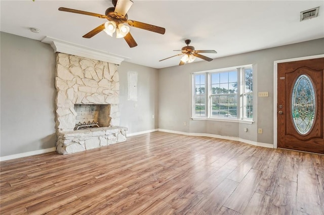 105 Palm Springs Dr, Slidell, LA 70458 - unfurnished living room featuring wood finished floors, baseboards, visible vents, ceiling fan, and a stone fireplace