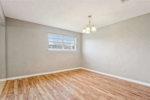 105 Palm Springs Dr, Slidell, LA 70458 - unfurnished room with a notable chandelier, baseboards, and light wood-type flooring