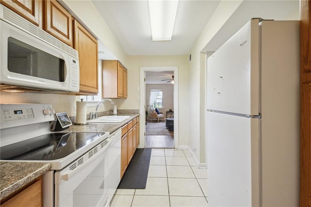 kitchen featuring a sink, light tile patterned floors, white appliances, a ceiling fan, and baseboards