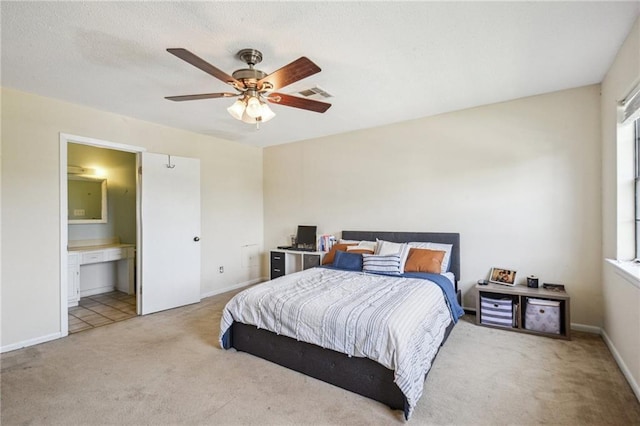 carpeted bedroom with visible vents, connected bathroom, a ceiling fan, and baseboards